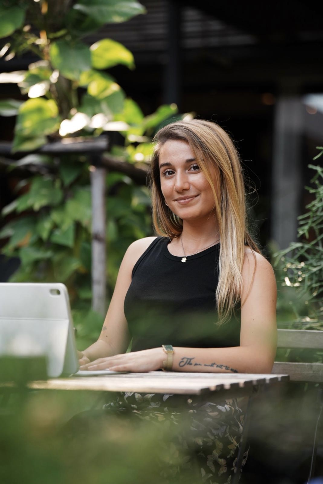 Ilaria Lico working from a garden cafe